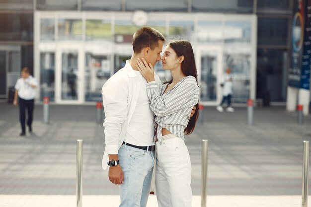 Hermosa pareja de pie cerca del aeropuerto