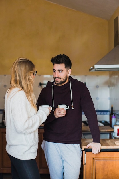 Hermosa pareja de pie en la cocina