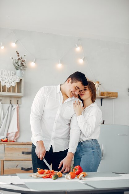 Hermosa pareja prepara comida en una cocina