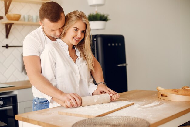 Hermosa pareja prepara comida en una cocina