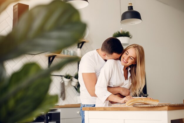 Hermosa pareja prepara comida en una cocina