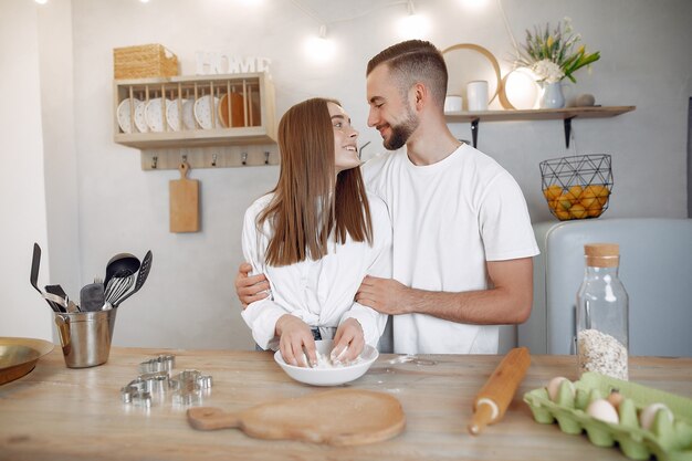 Hermosa pareja prepara comida en la cocina