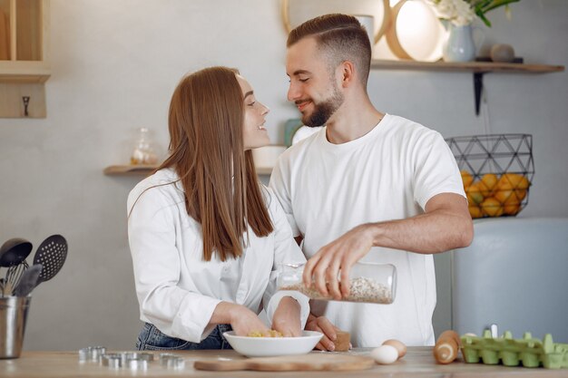 Hermosa pareja prepara comida en la cocina