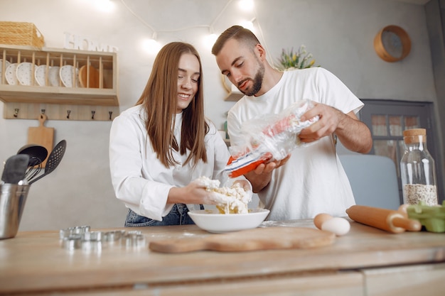 Hermosa pareja prepara comida en la cocina