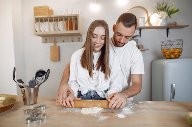 Hermosa pareja prepara comida en la cocina