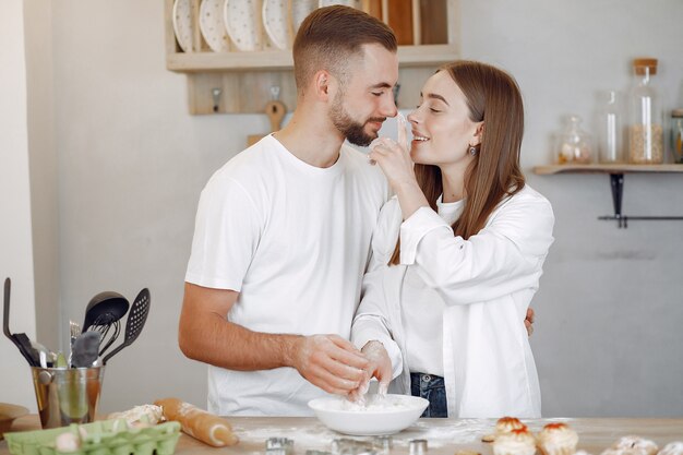 Hermosa pareja prepara comida en la cocina