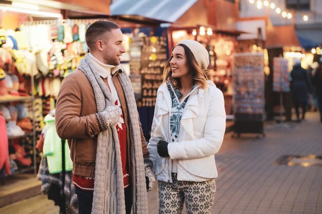 Hermosa pareja romántica disfruta de su día de Navidad en el tradicional mercado festivo.