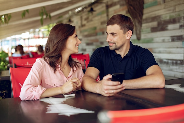 Hermosa pareja sentada en un café de verano