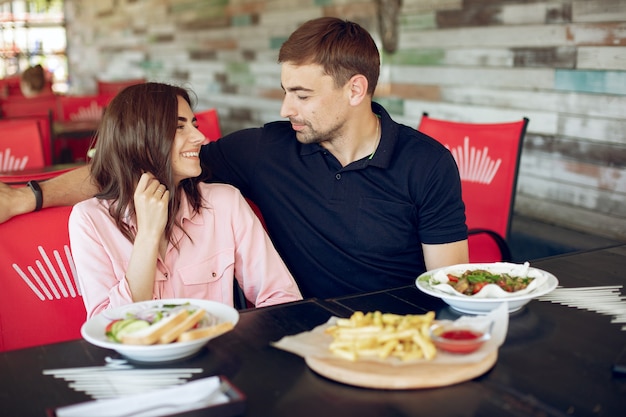 Hermosa pareja sentada en un café de verano