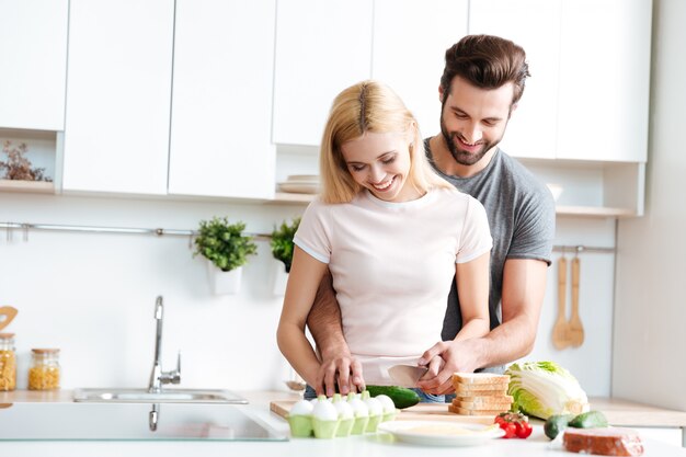 Hermosa pareja sonriente cocinando juntos en una cocina moderna