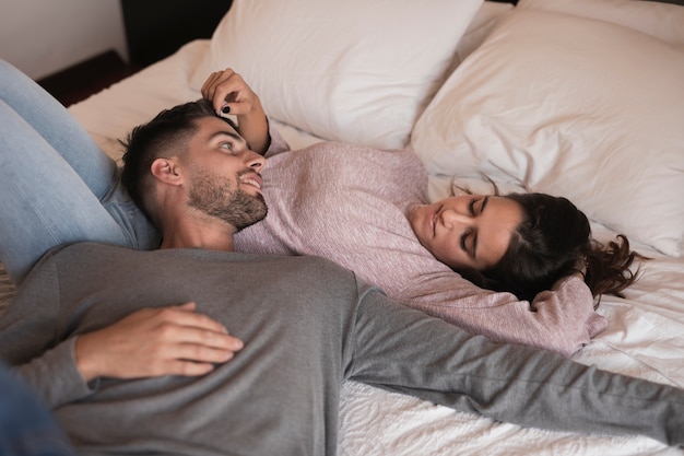 Hermosa pareja tendida en la cama