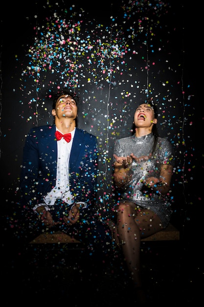 Foto gratuita hermosa pareja entre tirar confeti