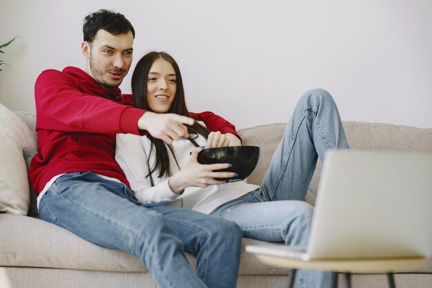 Hermosa pareja viendo películas en el sofá