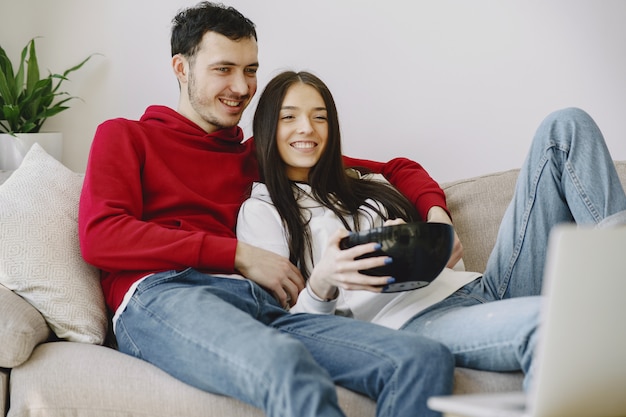 Hermosa pareja viendo películas en el sofá