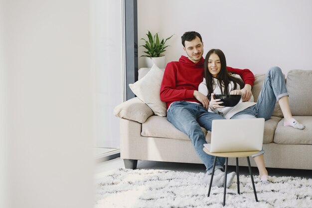 Hermosa pareja viendo películas en el sofá