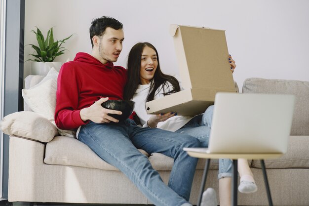 Hermosa pareja viendo películas en el sofá