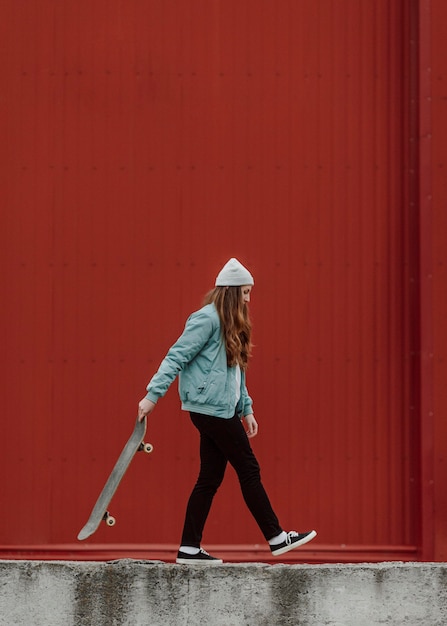 Hermosa patinadora sosteniendo su patineta