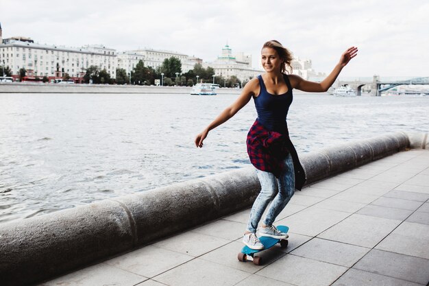 hermosa patineta rubia en el paseo marítimo