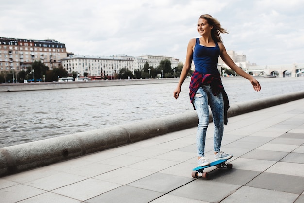 Foto gratuita hermosa patineta rubia en el paseo marítimo