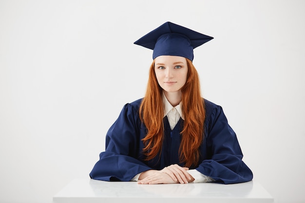 Hermosa pelirroja mujer graduada sonriendo.