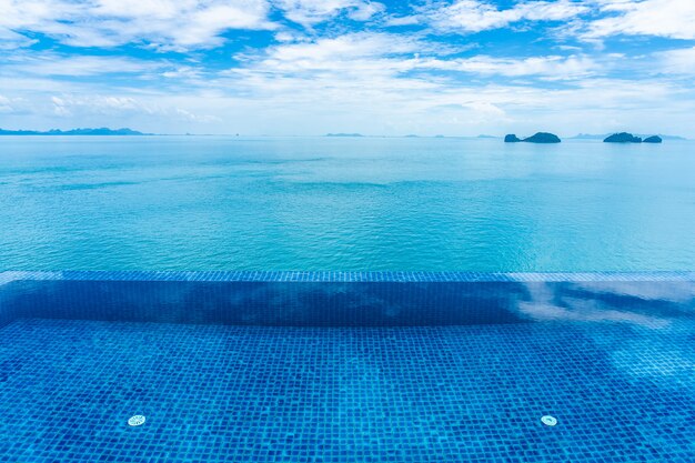 Hermosa piscina al aire libre con mar océano en cielo azul nube blanca