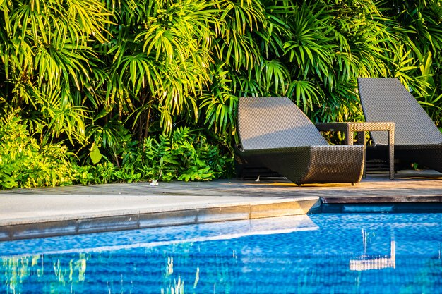 Hermosa piscina al aire libre con tumbona y sombrilla en el resort para viajes y vacaciones