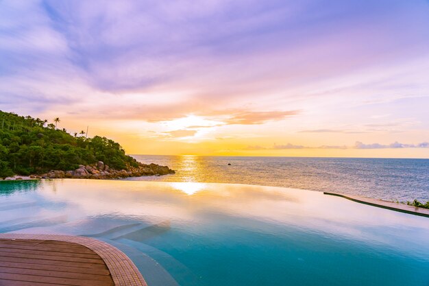 Hermosa piscina infinita al aire libre en el complejo hotelero con vista al mar y al cielo azul de nubes blancas