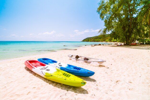 Hermosa playa paradisíaca y mar con kayak en bote.