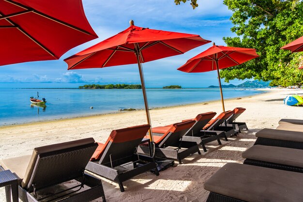 Hermosa playa tropical al aire libre mar océano con silla sombrilla y lounge deck alrededor de allí en el cielo azul nube blanca