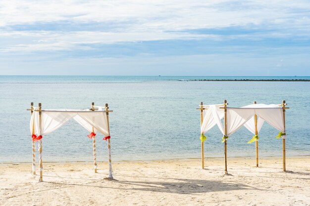 Hermosa playa tropical al aire libre mar océano con silla sombrilla y lounge deck alrededor de allí en el cielo azul nube blanca