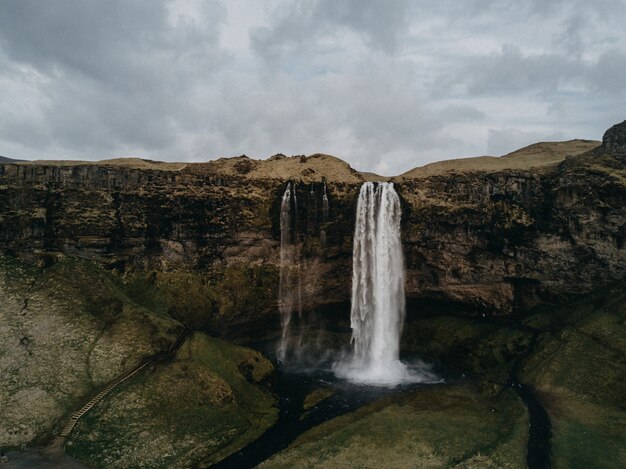 Hermosa y poderosa cascada que fluye en un río bajo un cielo nublado