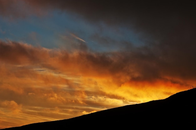 Hermosa puesta de sol y luces de sol anaranjadas sobre las montañas