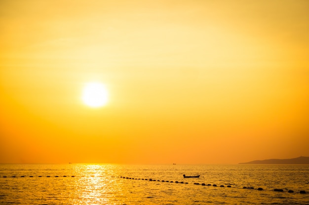 Hermosa puesta de sol en la playa y el mar