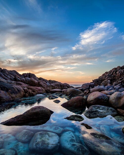 hermosa puesta de sol en la playa con rocas