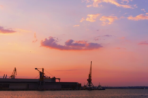 Hermosa puesta de sol sobre el área industrial de una ciudad suburbana con el sol reflejándose en el agua