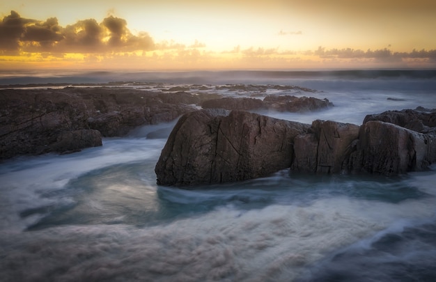 Foto gratuita hermosa puesta de sol sobre el mar rocoso