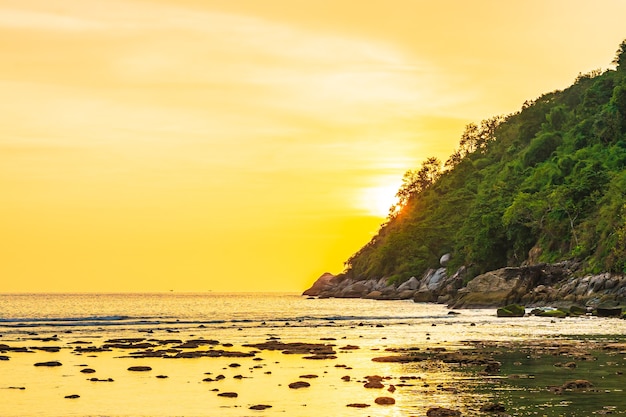 Hermosa puesta de sol sobre la montaña alrededor de la playa, mar, océano y roca