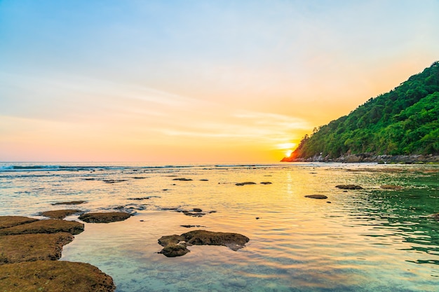 Hermosa puesta de sol sobre la montaña alrededor de la playa, mar, océano y roca