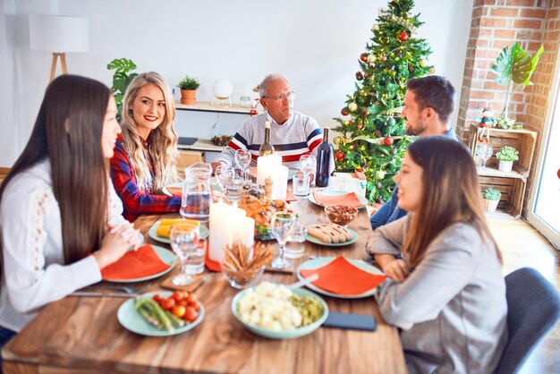 Hermosa reunión familiar sonriendo feliz y confiada. Comer pavo asado celebrando la navidad en casa