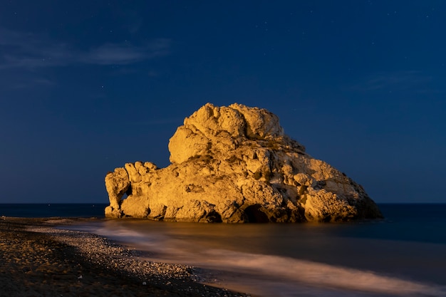 Hermosa roca en el agua por la noche