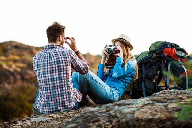 Hermosa rubia fotógrafa tomando foto de novio, fondo del cañón