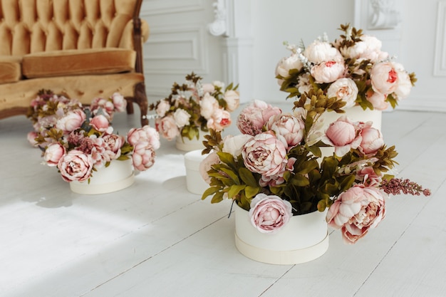 Hermosa sala de estar de Provance con sofá marrón junto a la chimenea con flores y velas