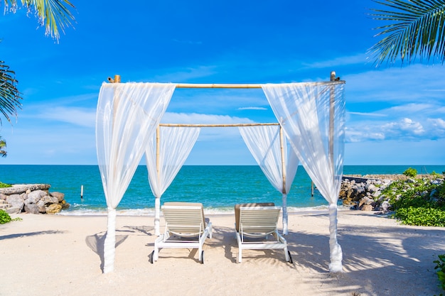 Foto gratuita hermosa sombrilla y silla alrededor de playa mar océano con cielo azul para viajar