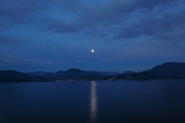 Hermosa tarde en el paisaje. Camino lunar en el lago y la montaña