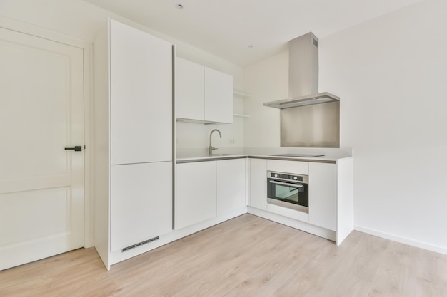 Hermosa toma de un diseño interior de una cocina en tonos blancos.