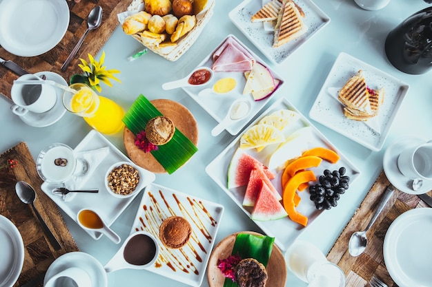 Hermosa variedad de comida para el desayuno servida en platos blanqueados en un resort tropical