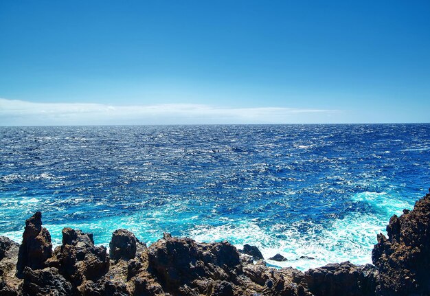 Hermosa vista desde el acantilado de la montaña hasta el océano con cielo azul y nubes