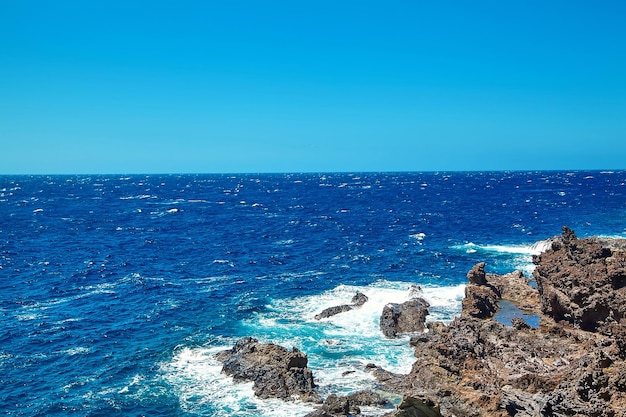 Foto gratuita hermosa vista desde el acantilado de la montaña hasta el océano con cielo azul y nubes