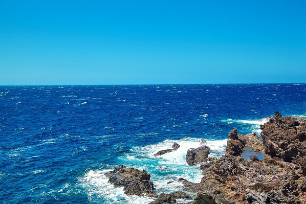 Hermosa vista desde el acantilado de la montaña hasta el océano con cielo azul y nubes