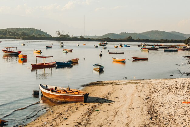 Hermosa vista de una bahía con barcos de pesca cerca de una orilla arenosa